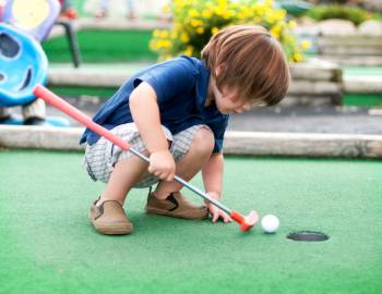 kid playing mini golf